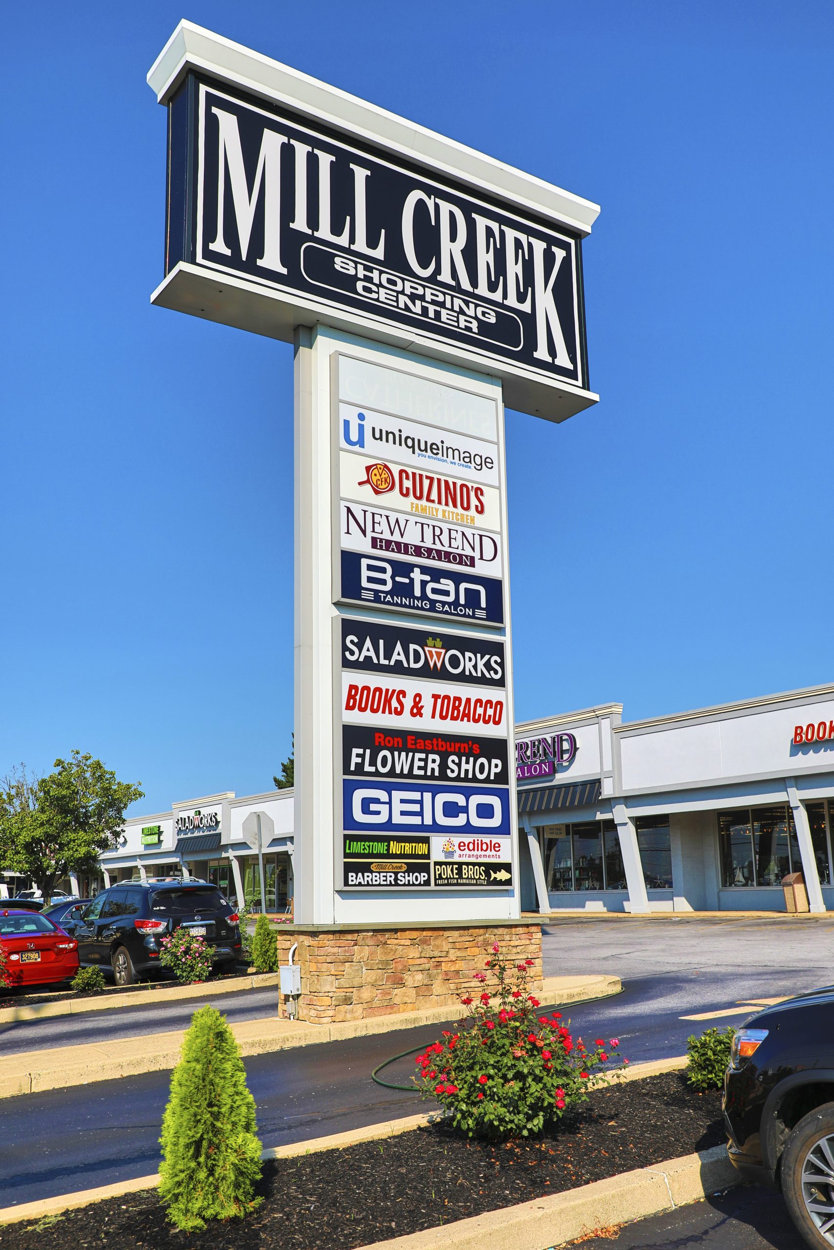 A pylon sign fitted with various business signs, atop of a brick foundation