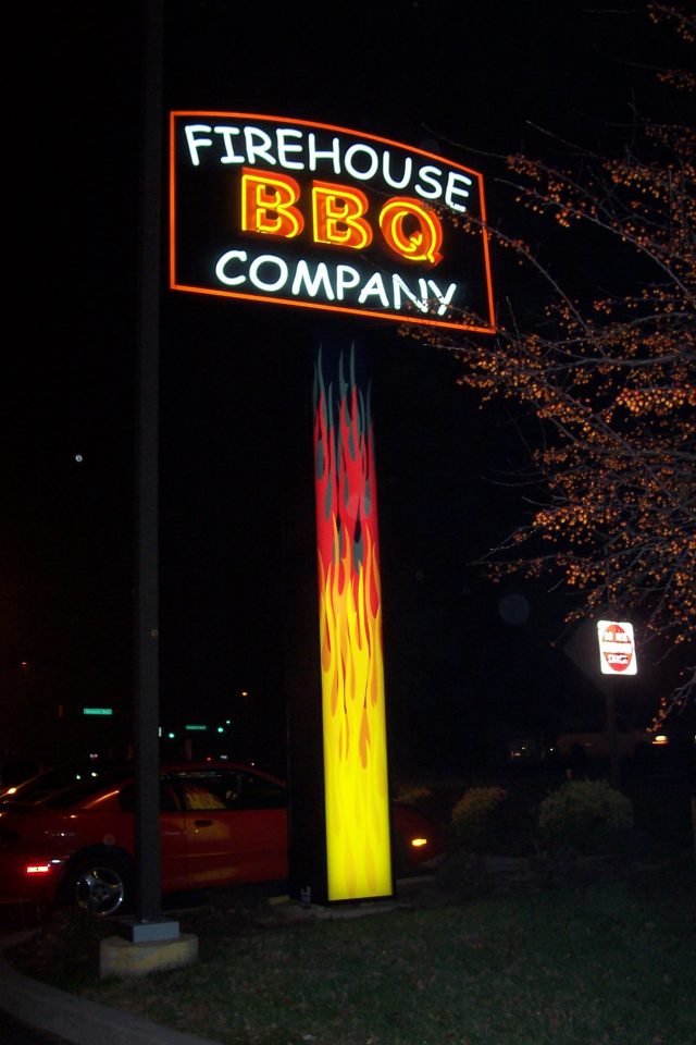 A pylon restaurant business sign made by HES signs, placed next to a parking lot.