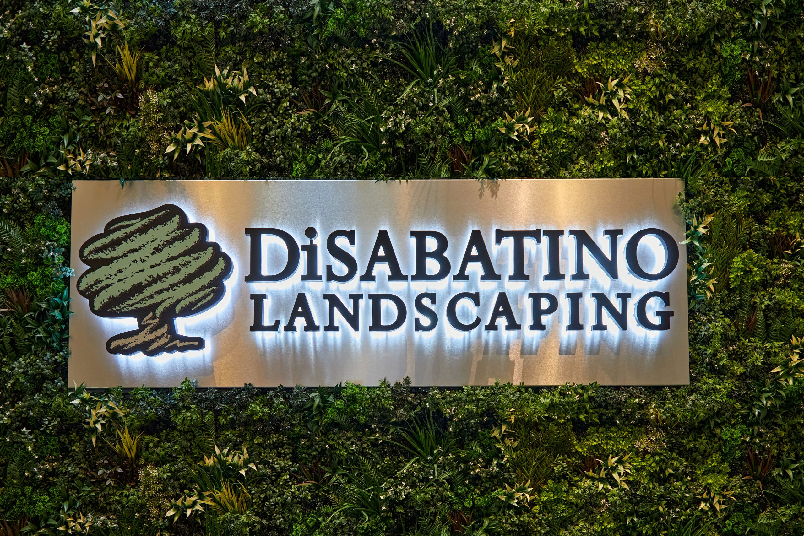 An interior lighted sign for a business place, surrounded by an espaliar designed tree
